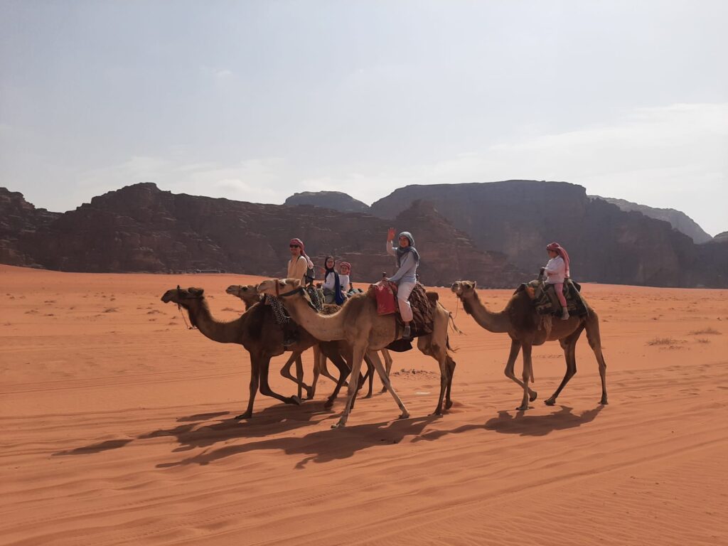 Guests on a camel tour through the Wadi Rum desert, Jordan