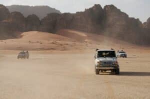 4x4 jeeps driving through the wadi rum desert on a tour